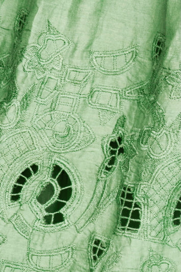 Green eyelet dress on a hanger in store