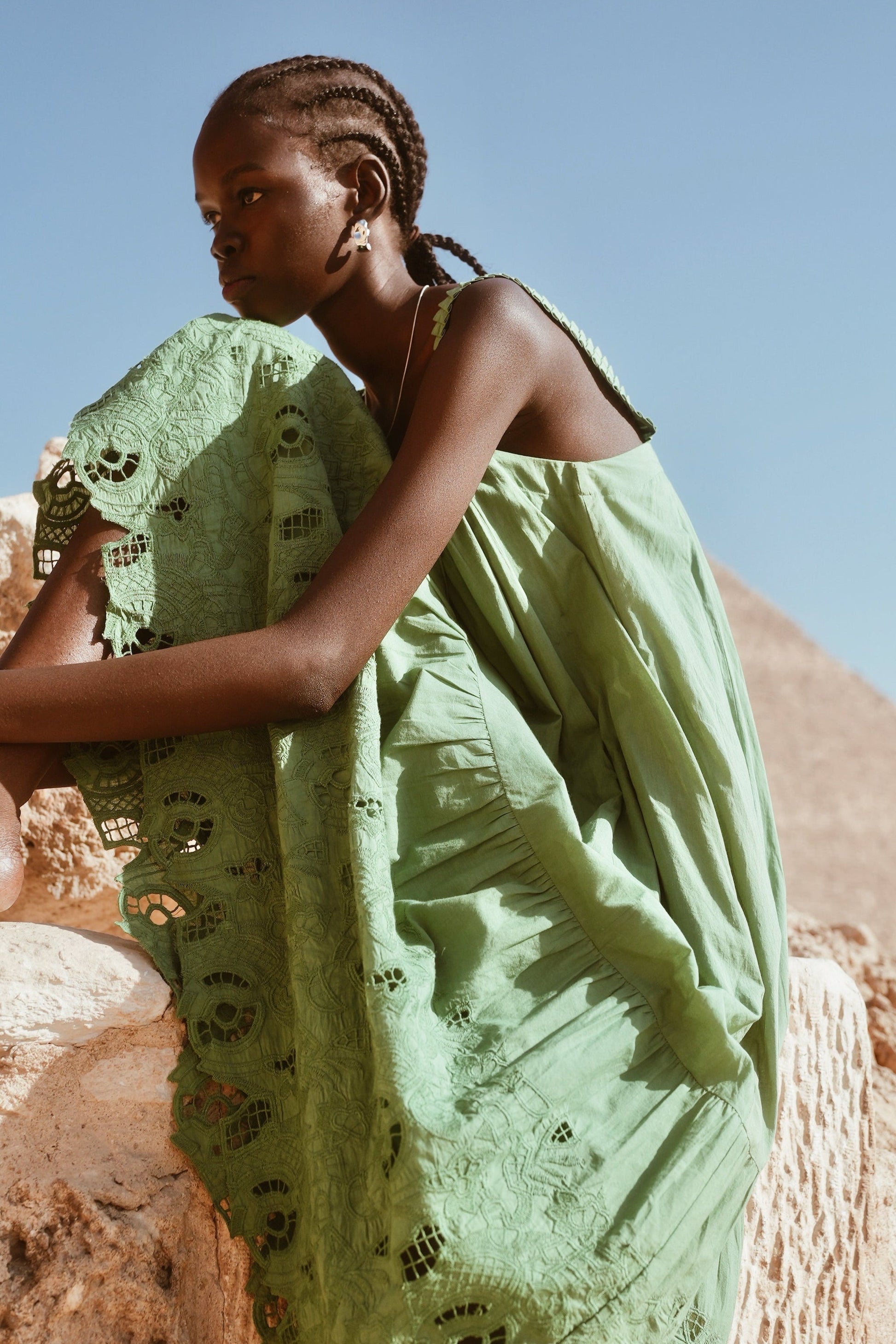 Green eyelet dress on a hanger in store