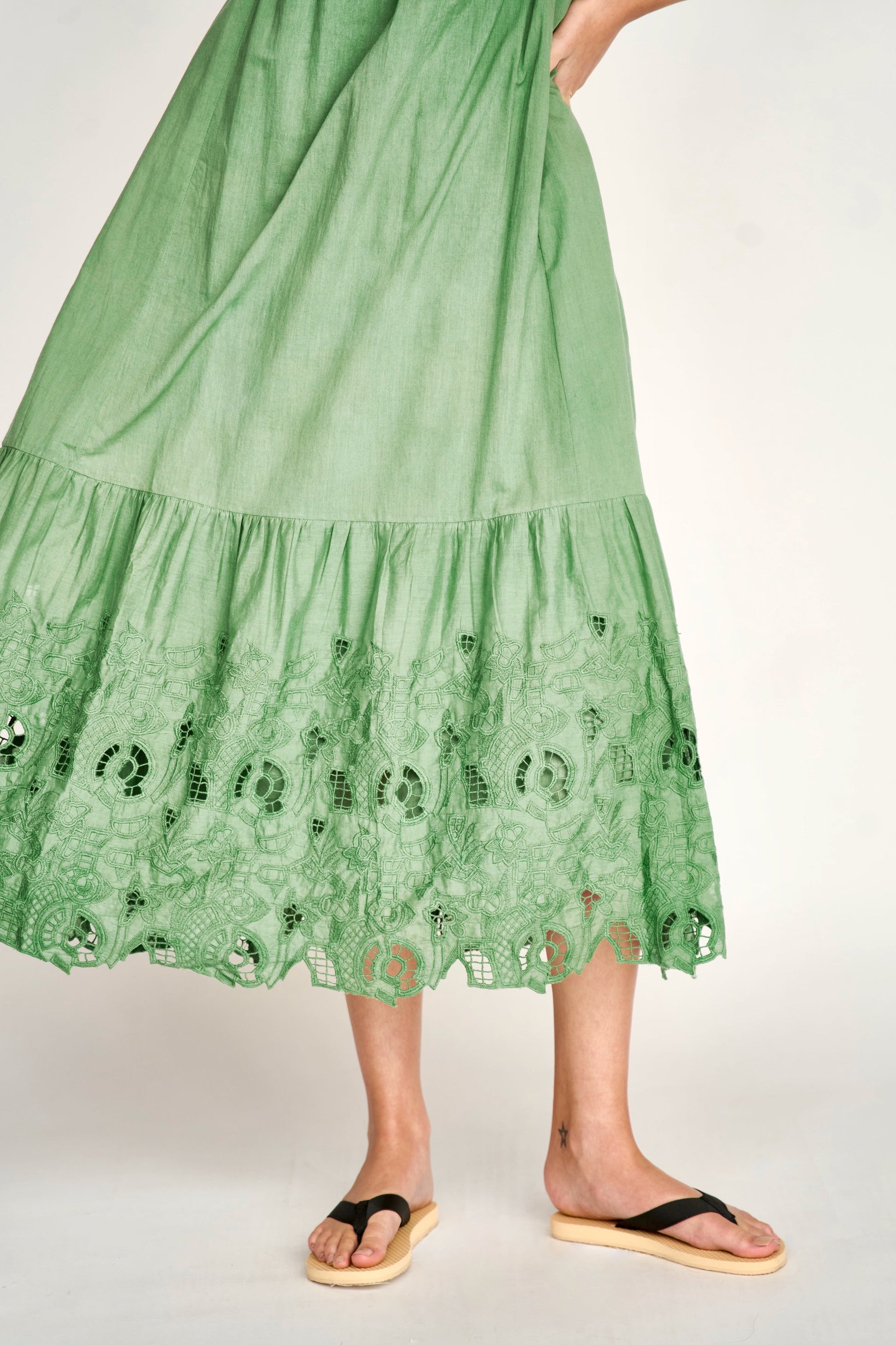 Green eyelet dress on a hanger in store