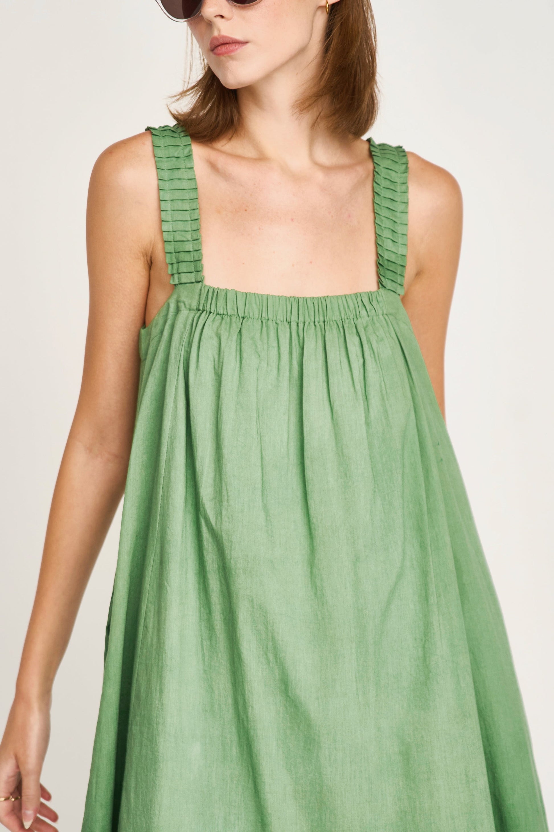 Green eyelet dress on a hanger in store