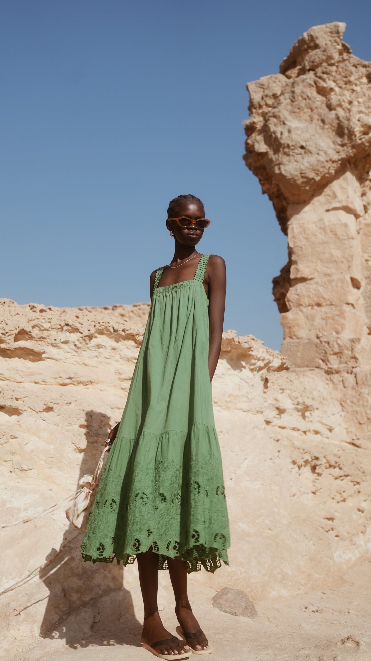 Green eyelet dress on a hanger in store