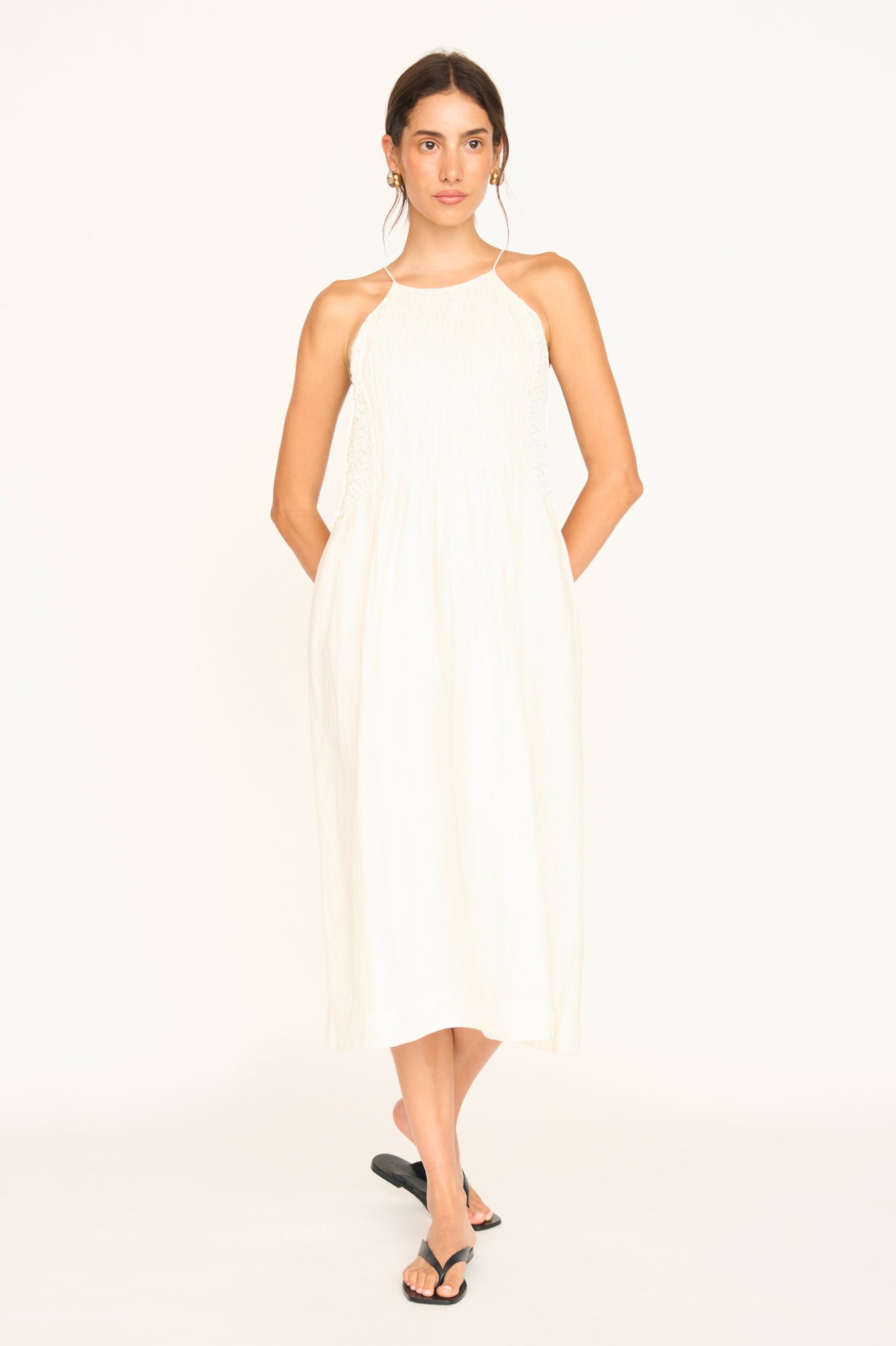 White linen smocked dress on a hanger in store