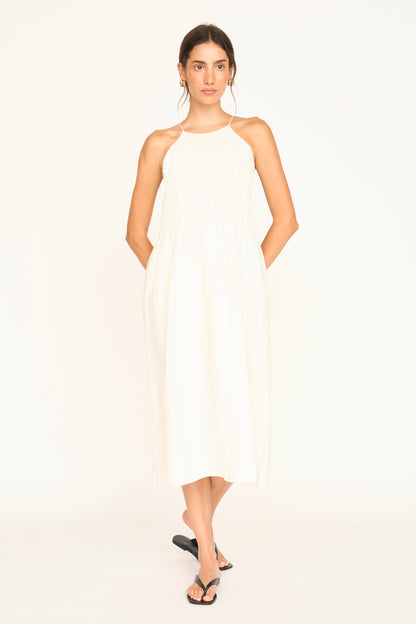 White linen smocked dress on a hanger in store