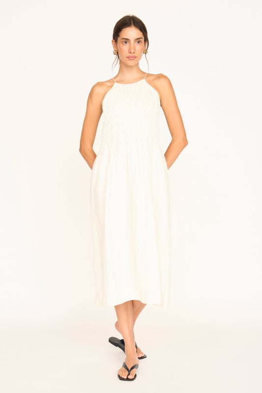 White linen smocked dress on a hanger in store