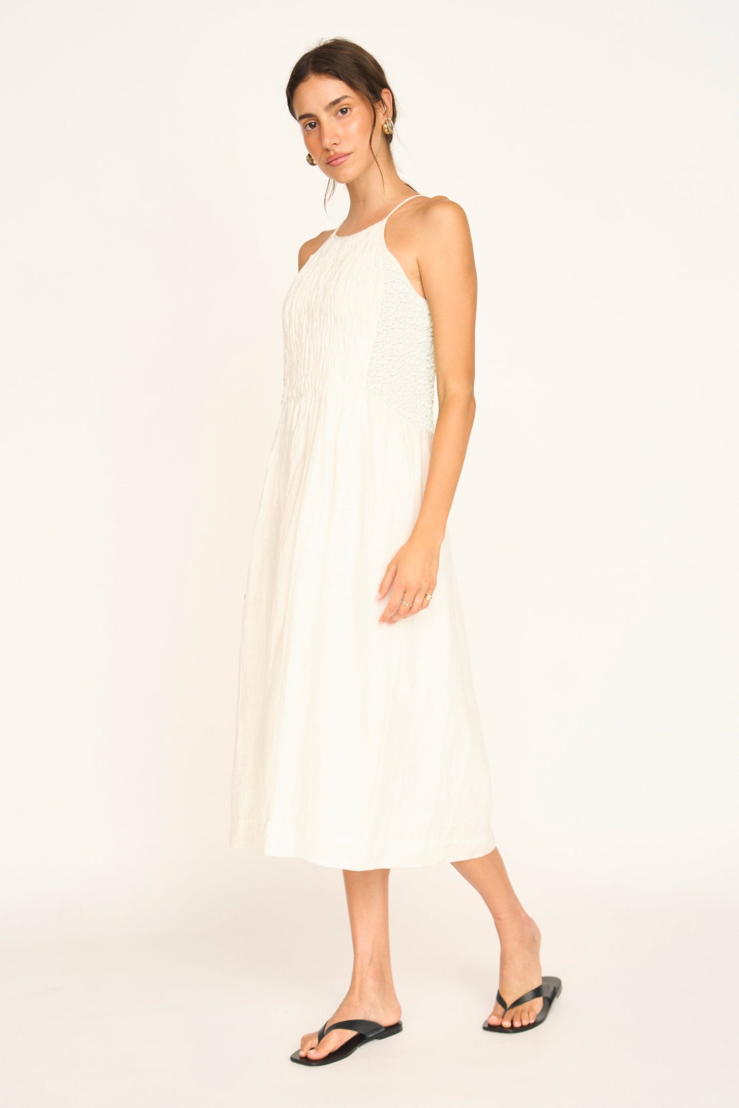 White linen smocked dress on a hanger in store