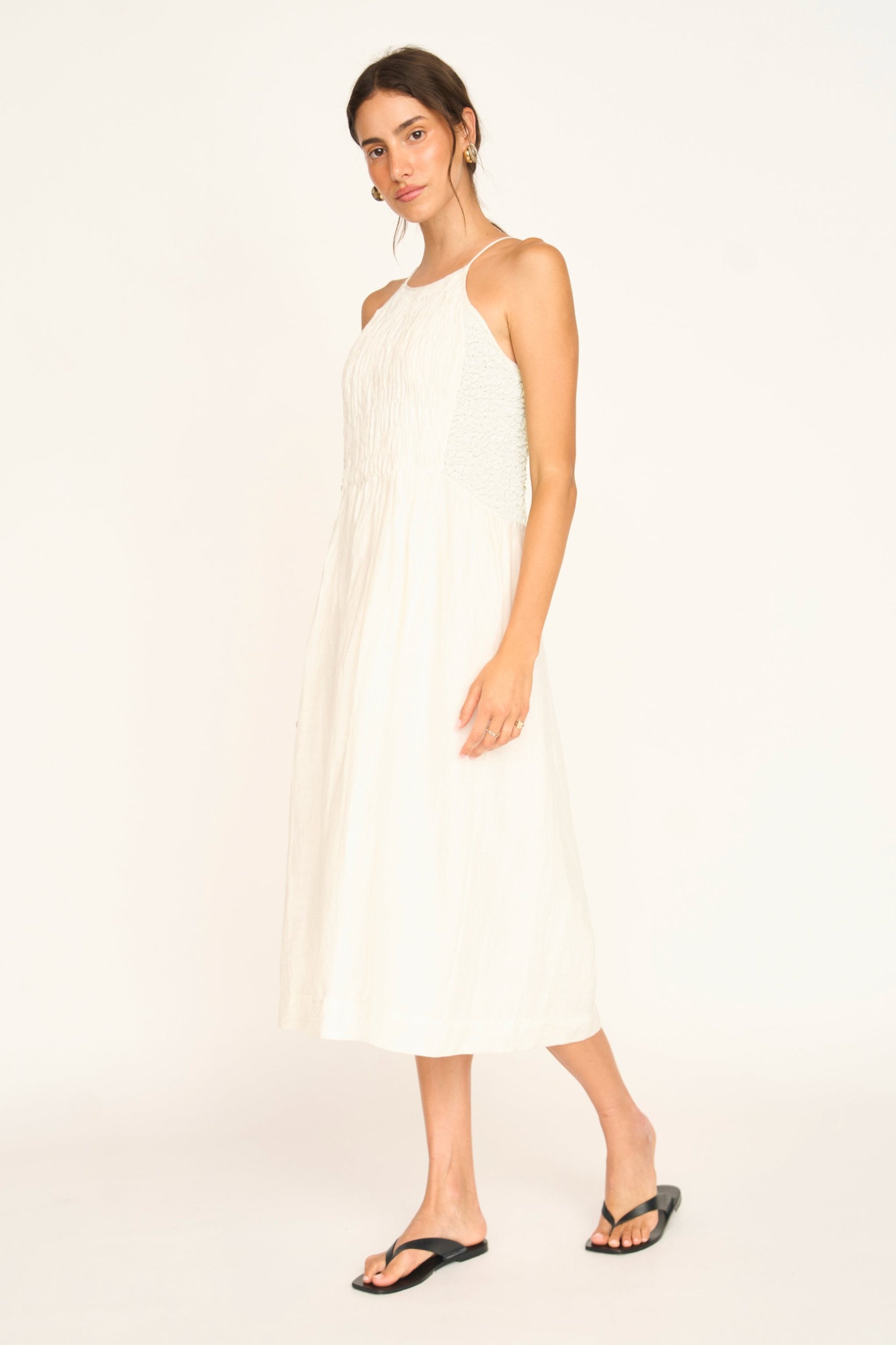 White linen smocked dress on a hanger in store