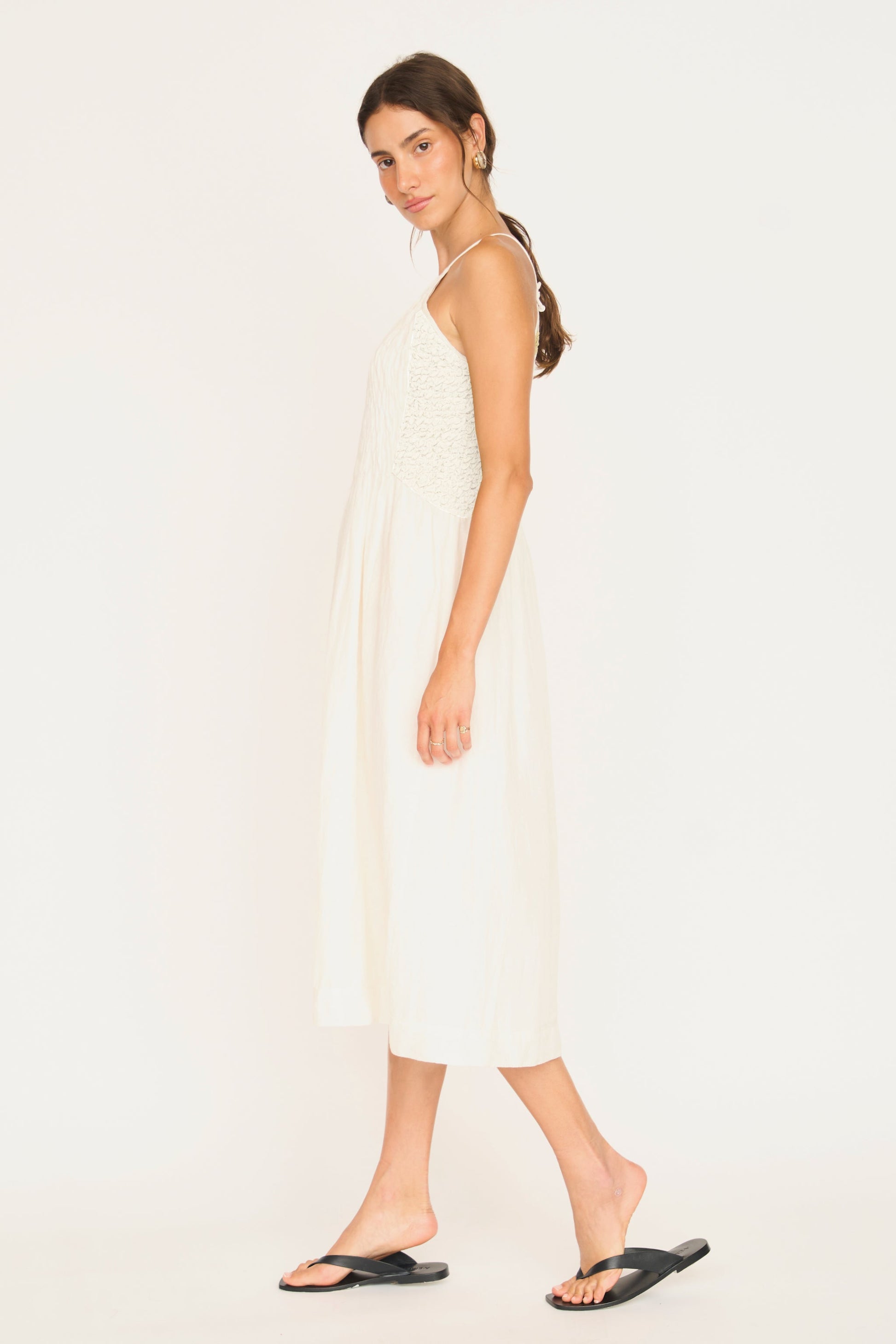 White linen smocked dress on a hanger in store