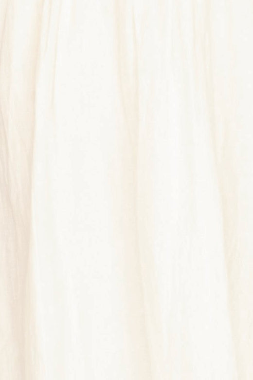 White linen smocked dress on a hanger in store