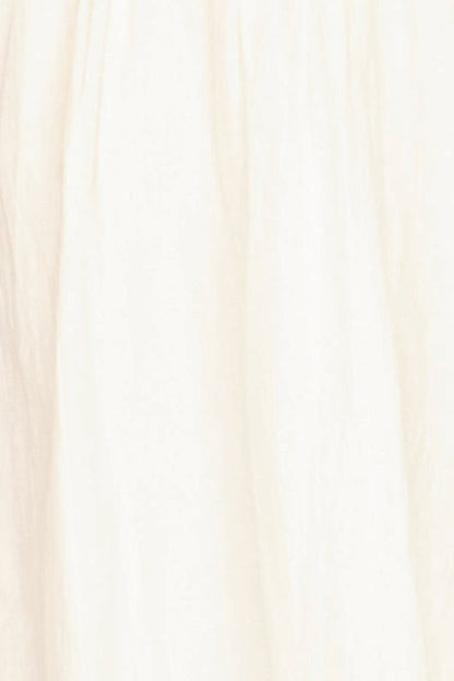 White linen smocked dress on a hanger in store