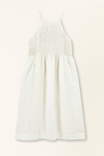 White linen smocked dress on a hanger in store