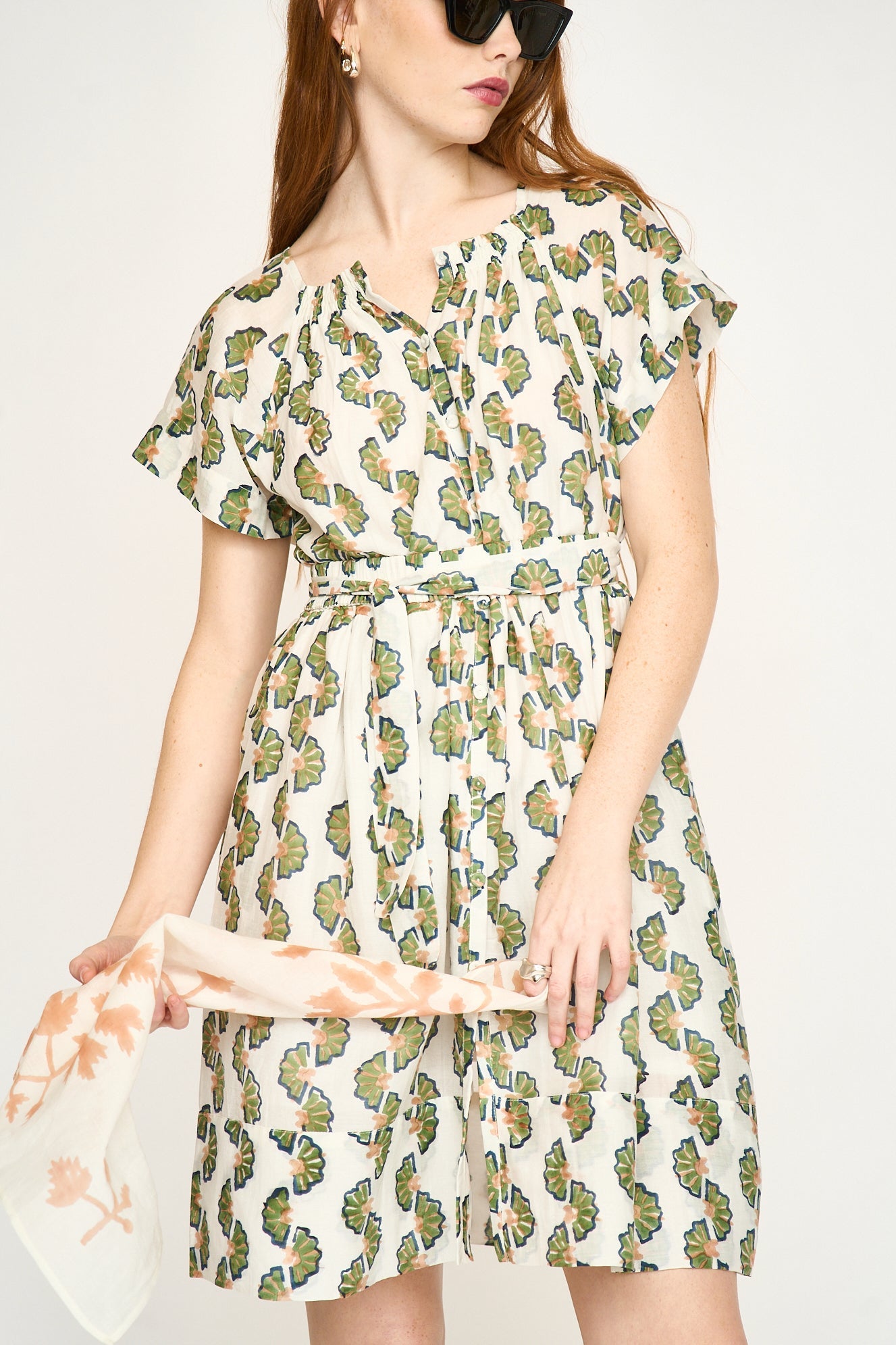 Green cotton short dress on a hanger in store