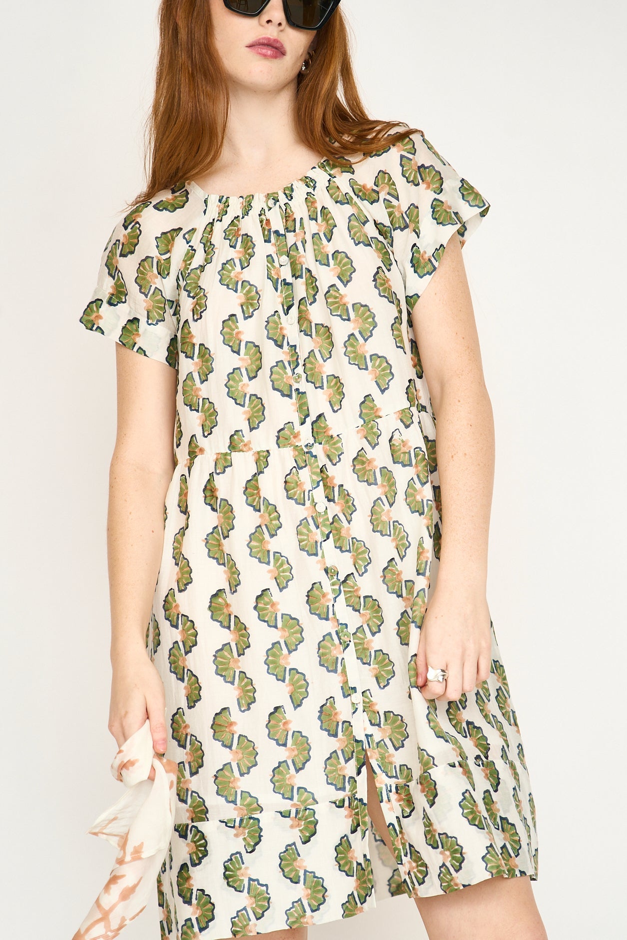 Green cotton short dress on a hanger in store
