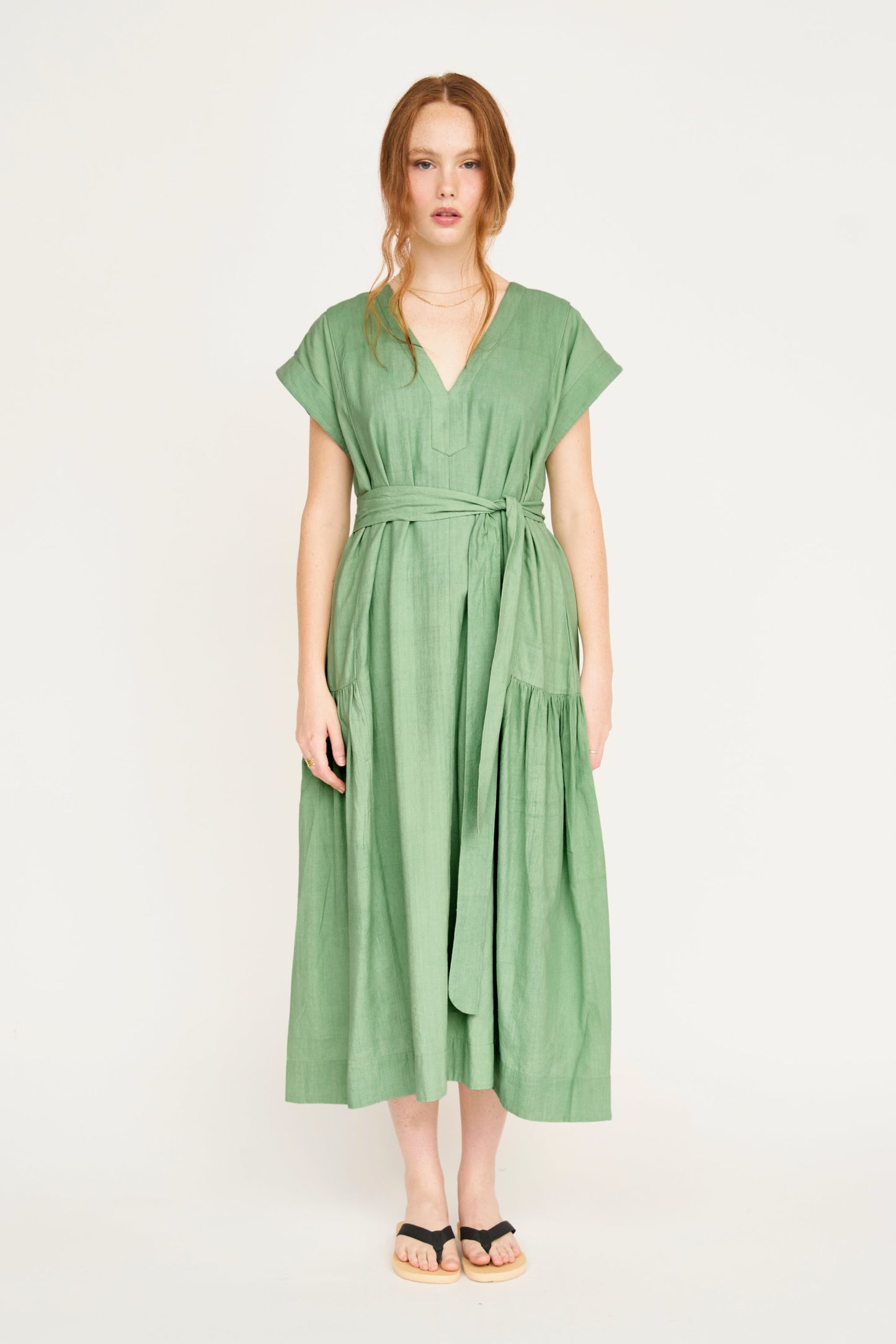 Green cotton midi dress on a hanger in store