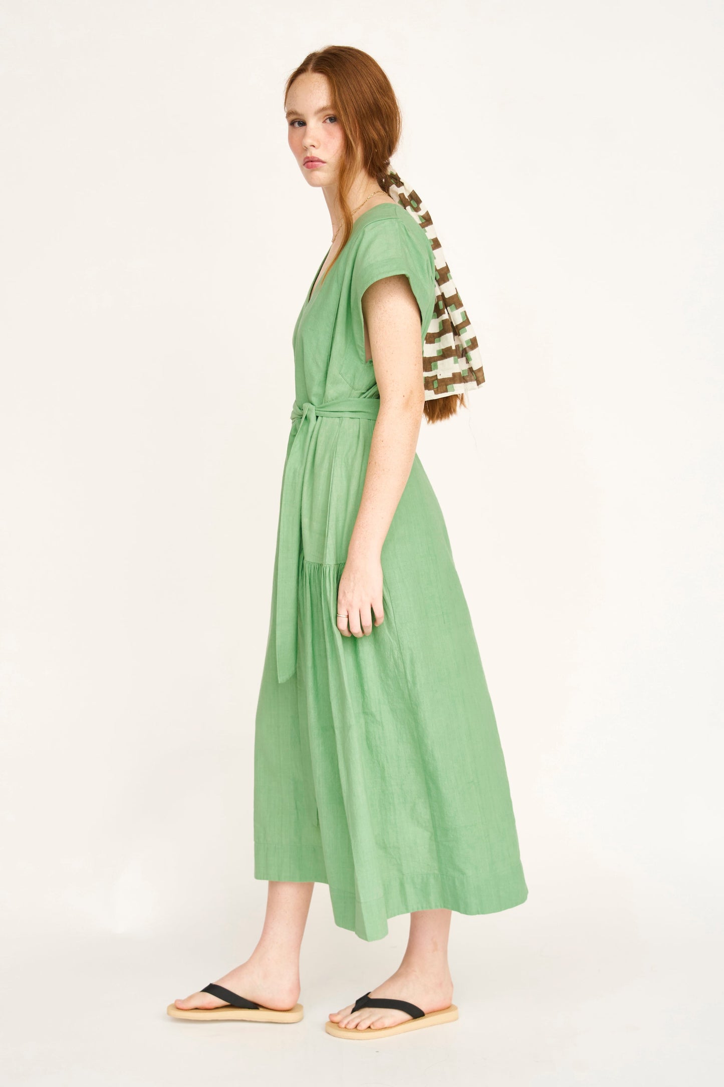 Green cotton midi dress on a hanger in store