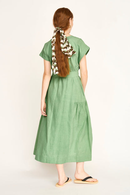 Green cotton midi dress on a hanger in store