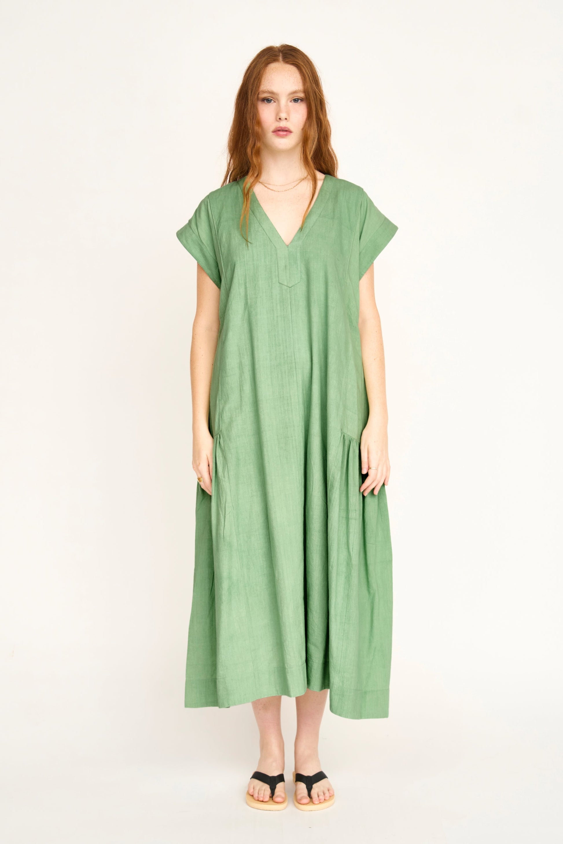 Green cotton midi dress on a hanger in store