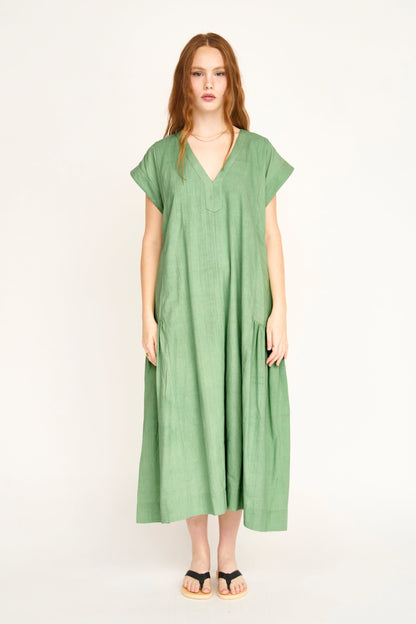 Green cotton midi dress on a hanger in store