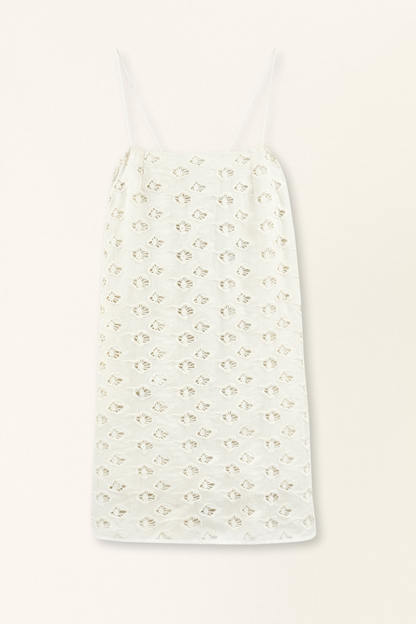 White eyelet mini dress on a hanger in store