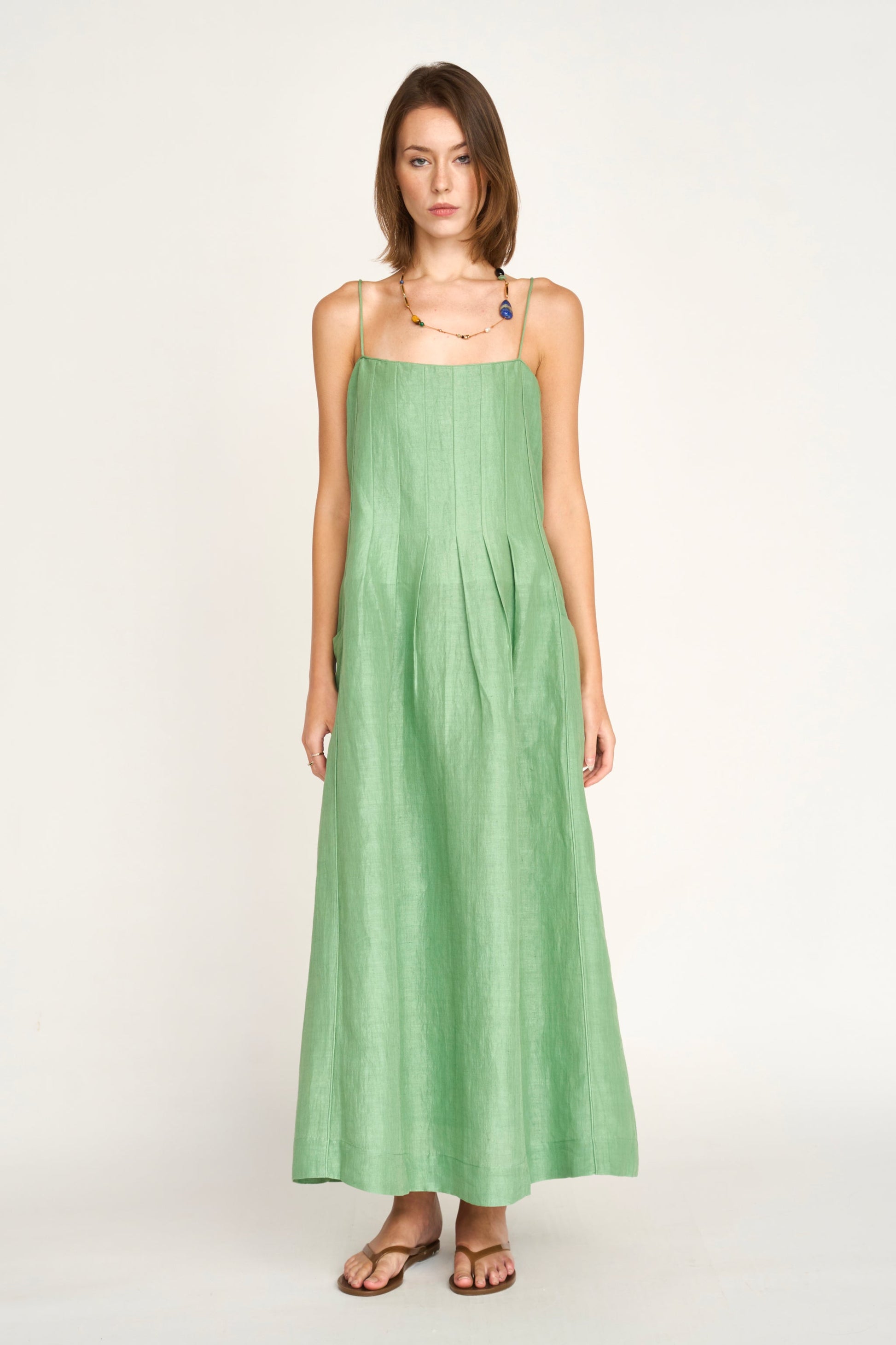 Green linen maxi dress on a hanger in store