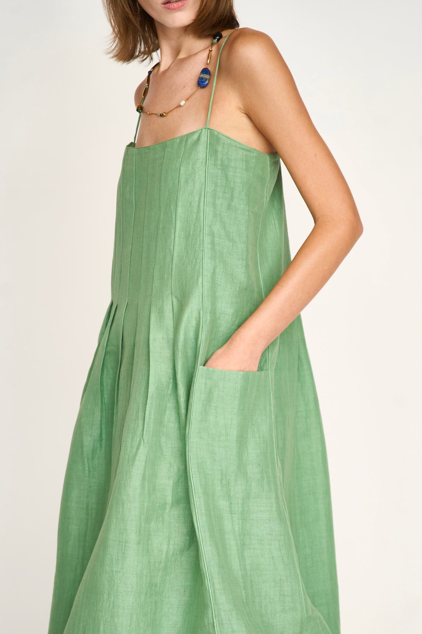 Green linen maxi dress on a hanger in store