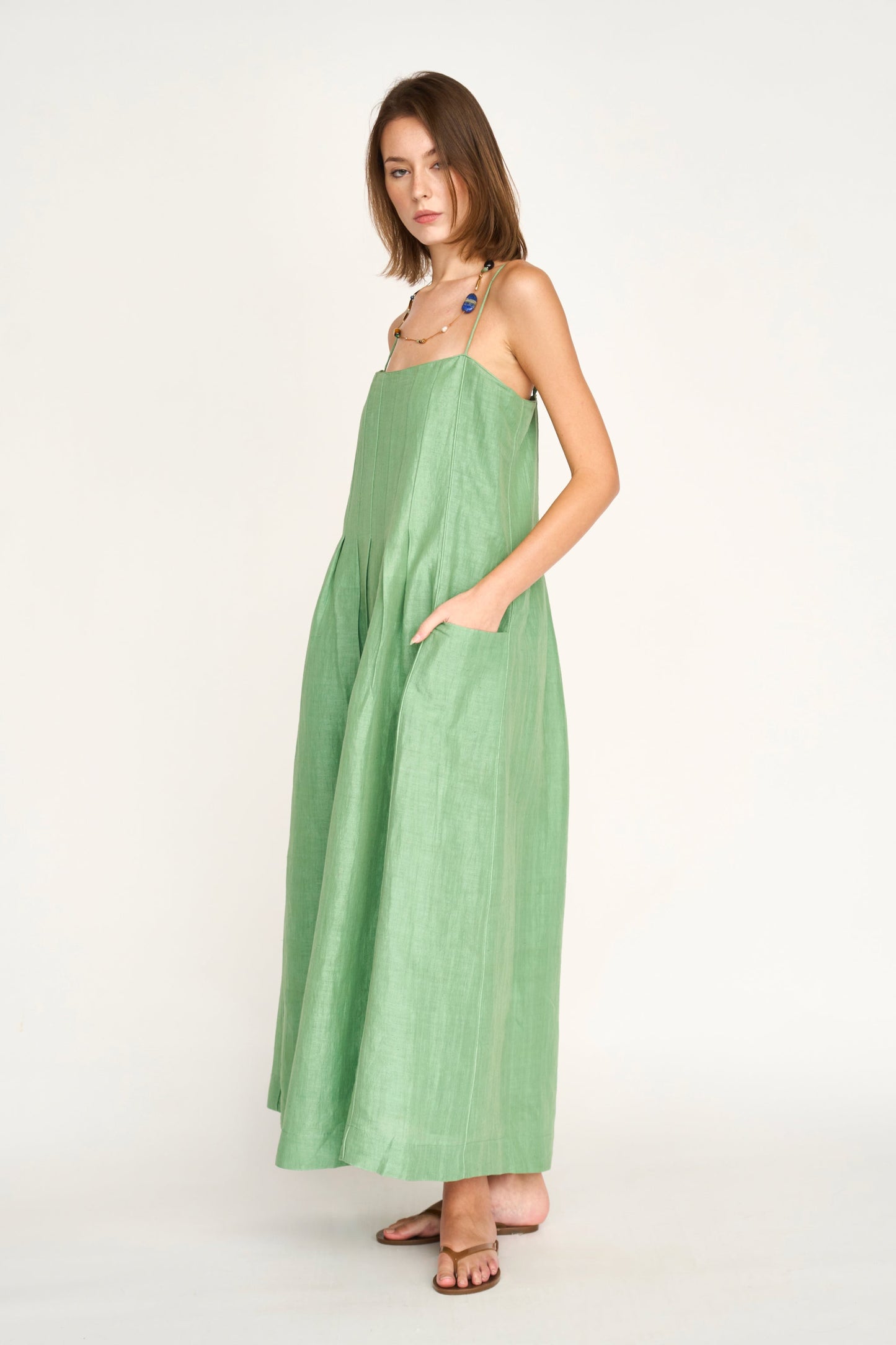 Green linen maxi dress on a hanger in store