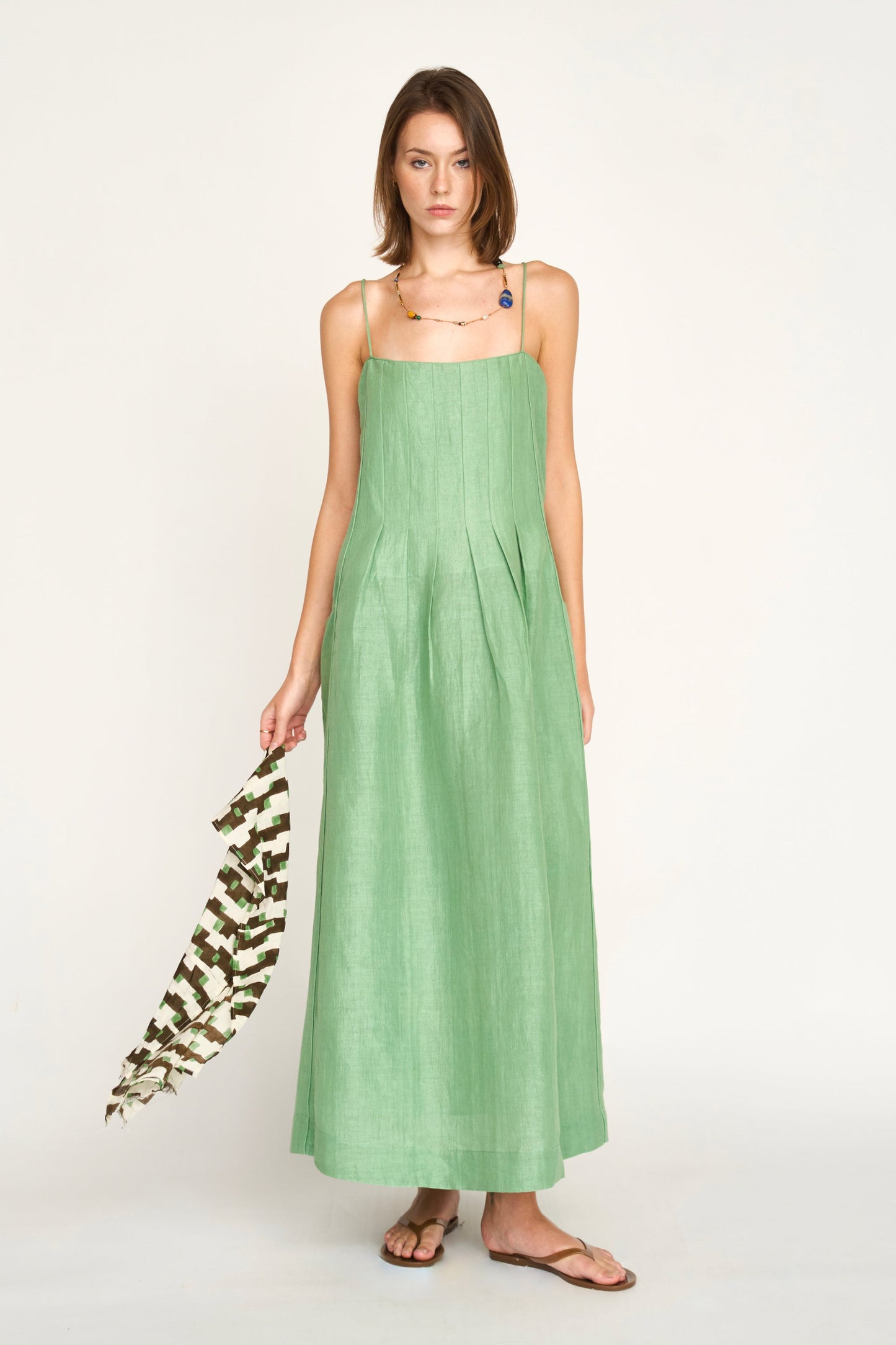 Green linen maxi dress on a hanger in store