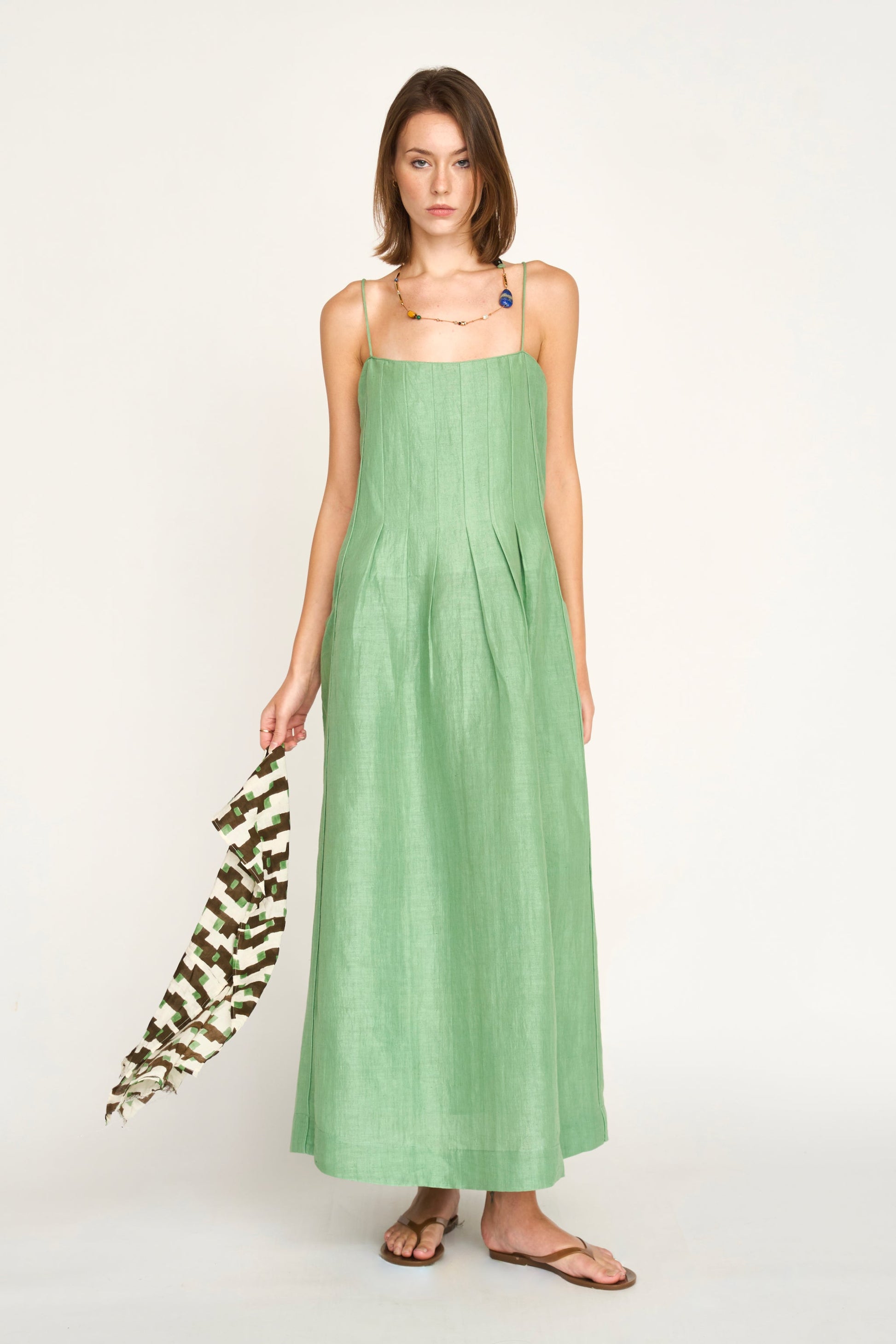 Green linen maxi dress on a hanger in store