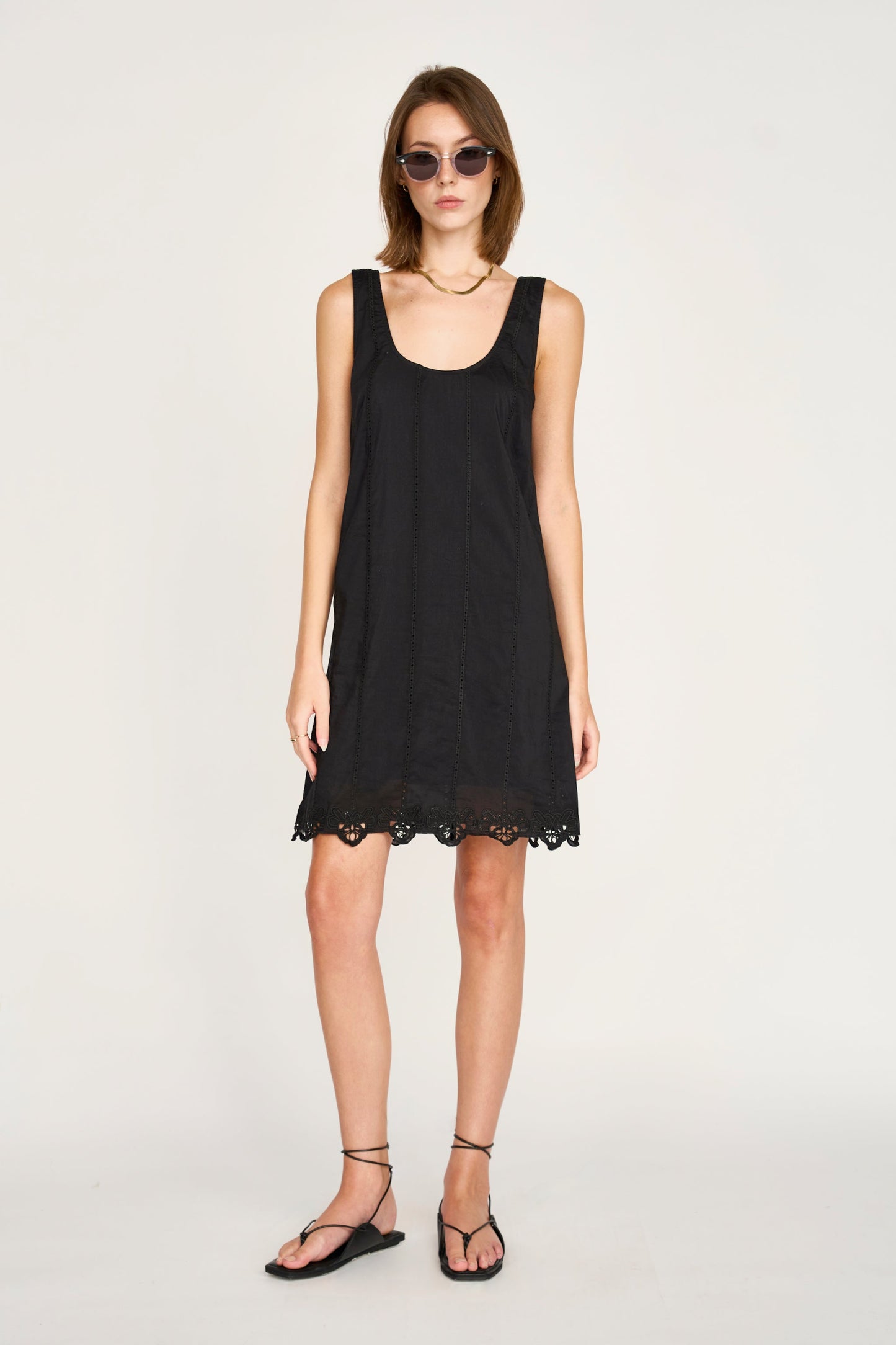 Black eyelet mini dress on a hanger in store