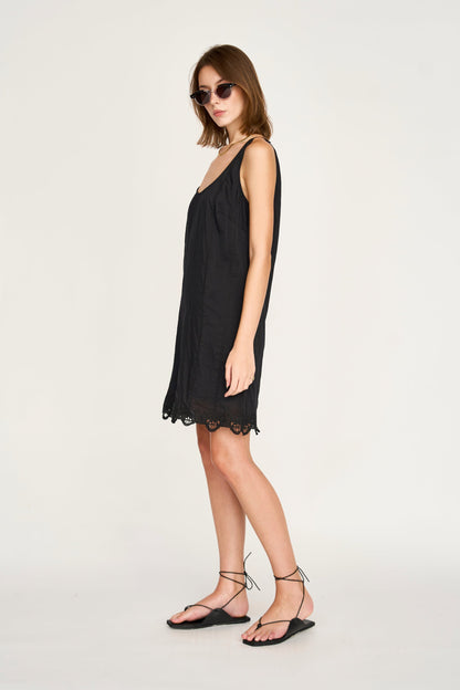 Black eyelet mini dress on a hanger in store
