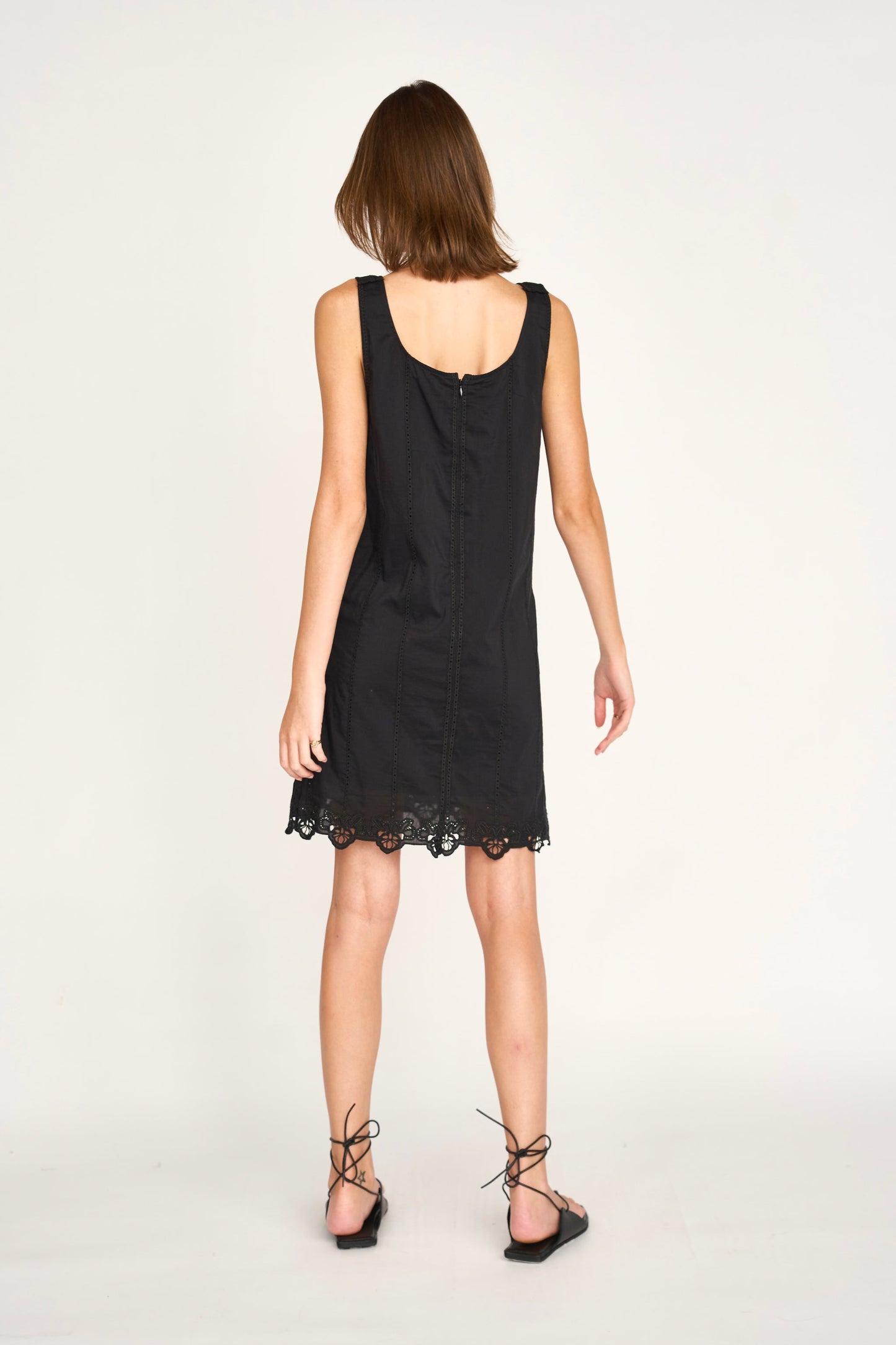 Black eyelet mini dress on a hanger in store