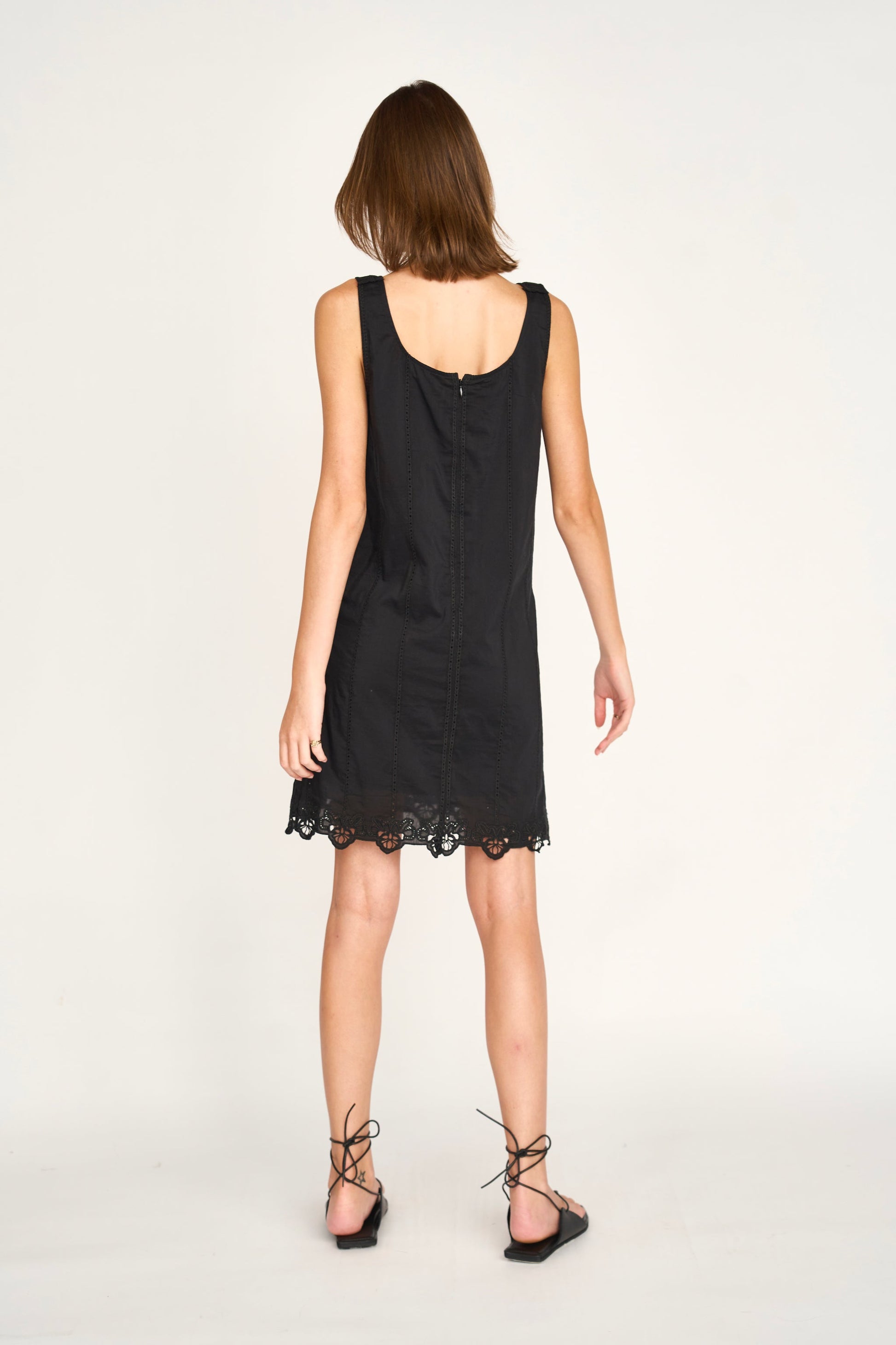 Black eyelet mini dress on a hanger in store