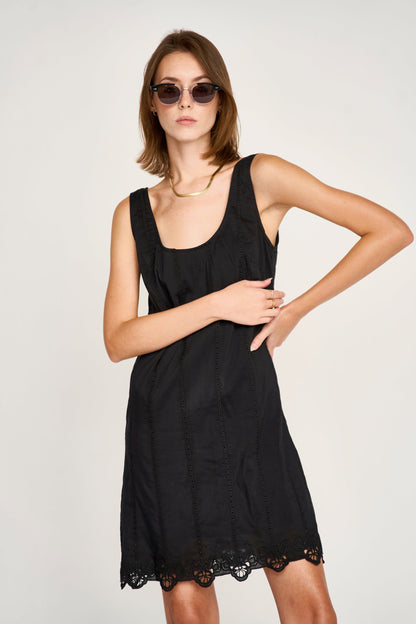 Black eyelet mini dress on a hanger in store