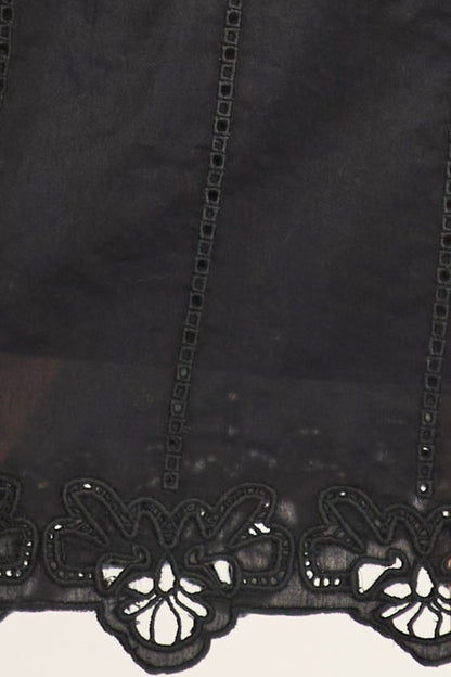 Black eyelet mini dress on a hanger in store